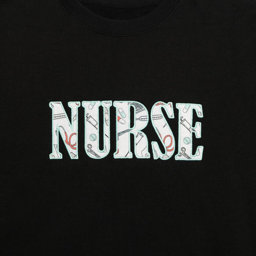 Close-up of the Nurse design appliqued on the chest of the Black crewneck