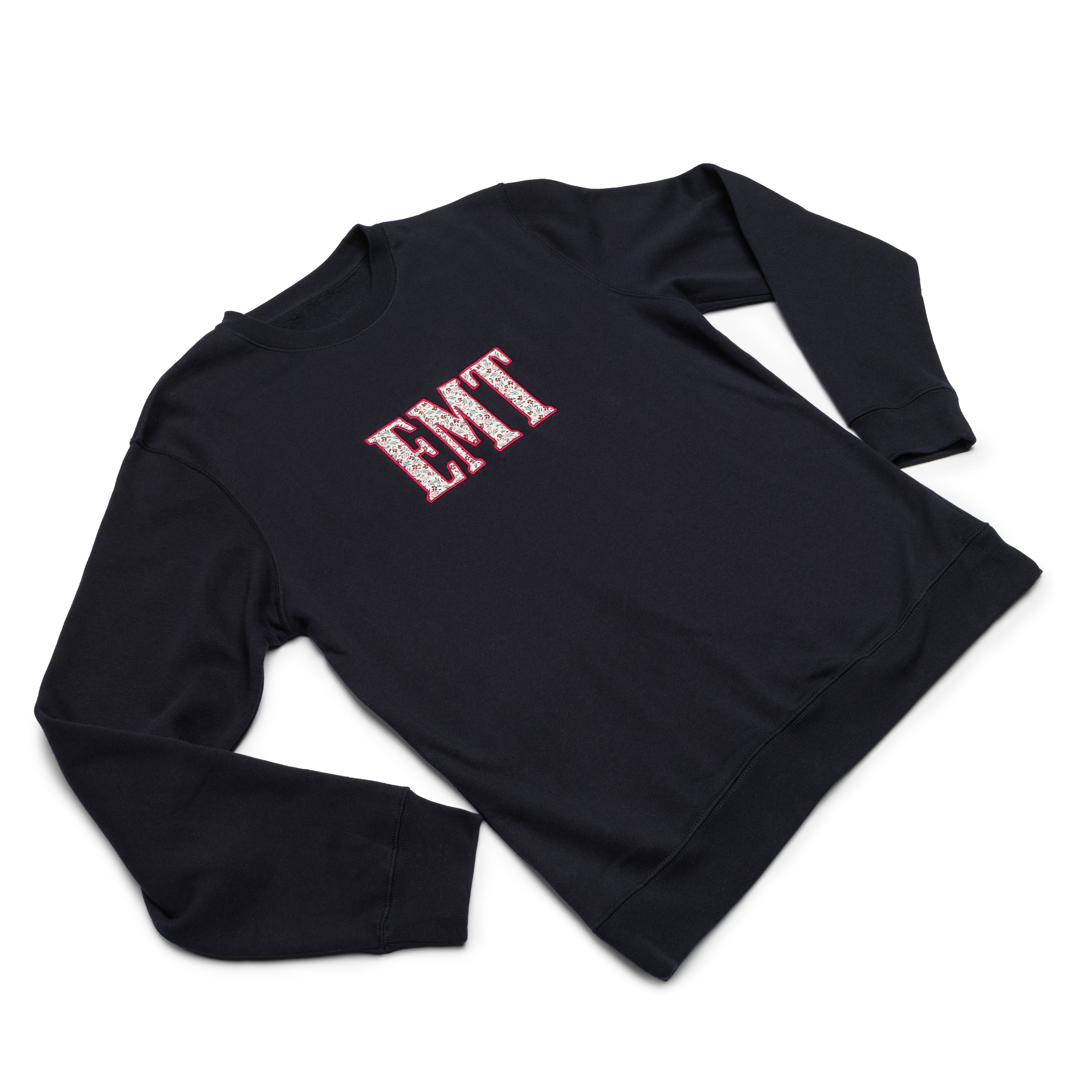 Classic Navy crewneck worn at an angle with the EMT design appliqued on the chest
