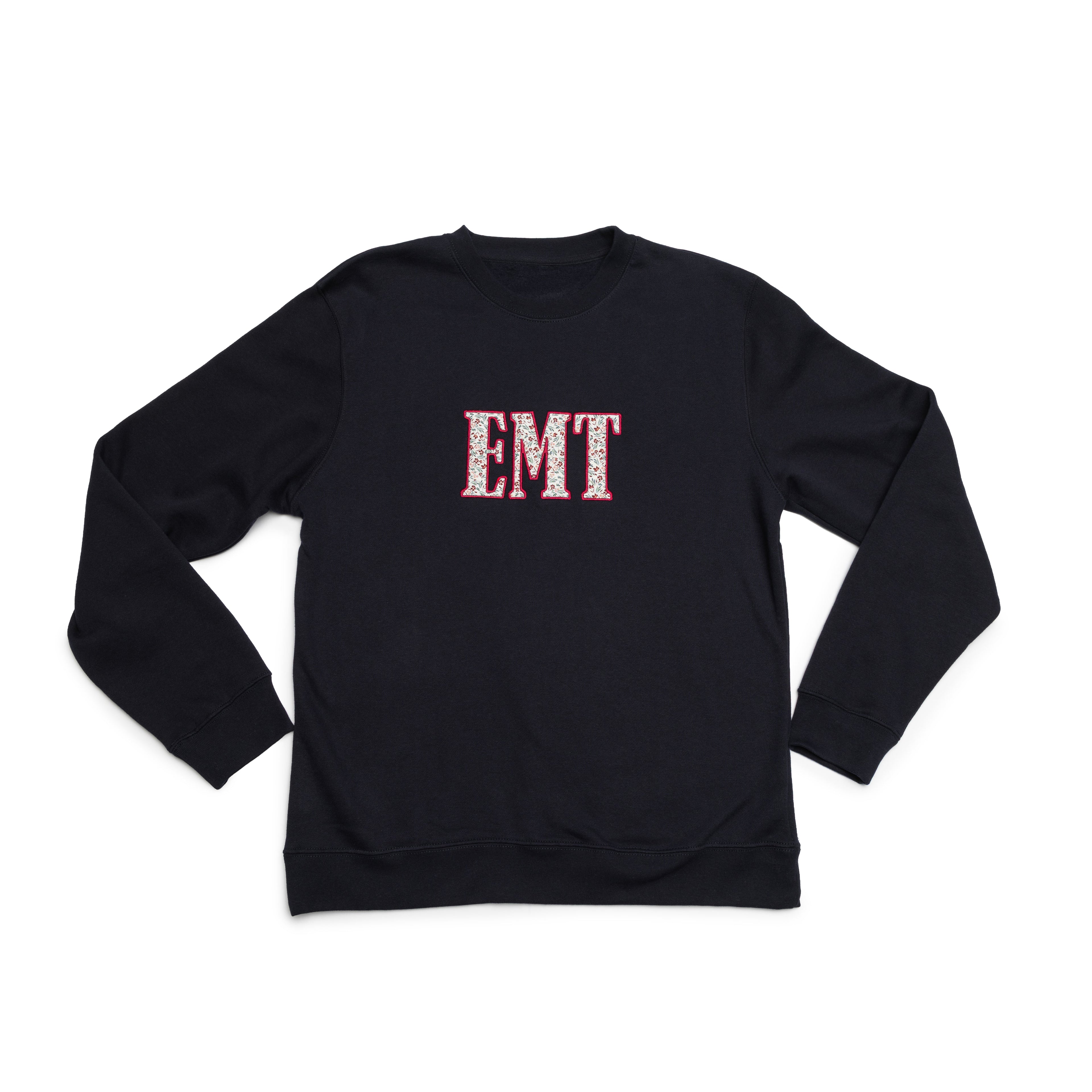 Classic Navy crewneck laid flat with the EMT design appliqued on the chest
