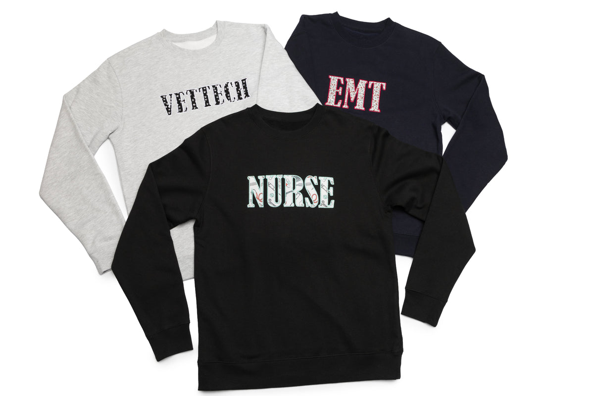 Three Huddle crewnecks stacked together, each with its own profession lettering design