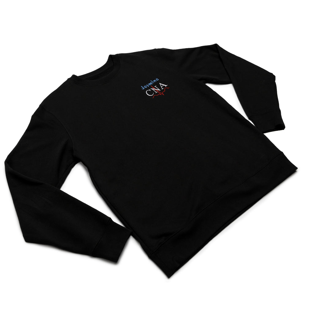 Black crewneck worn at an angle with a custom name and the CNA design embroidered on the chest