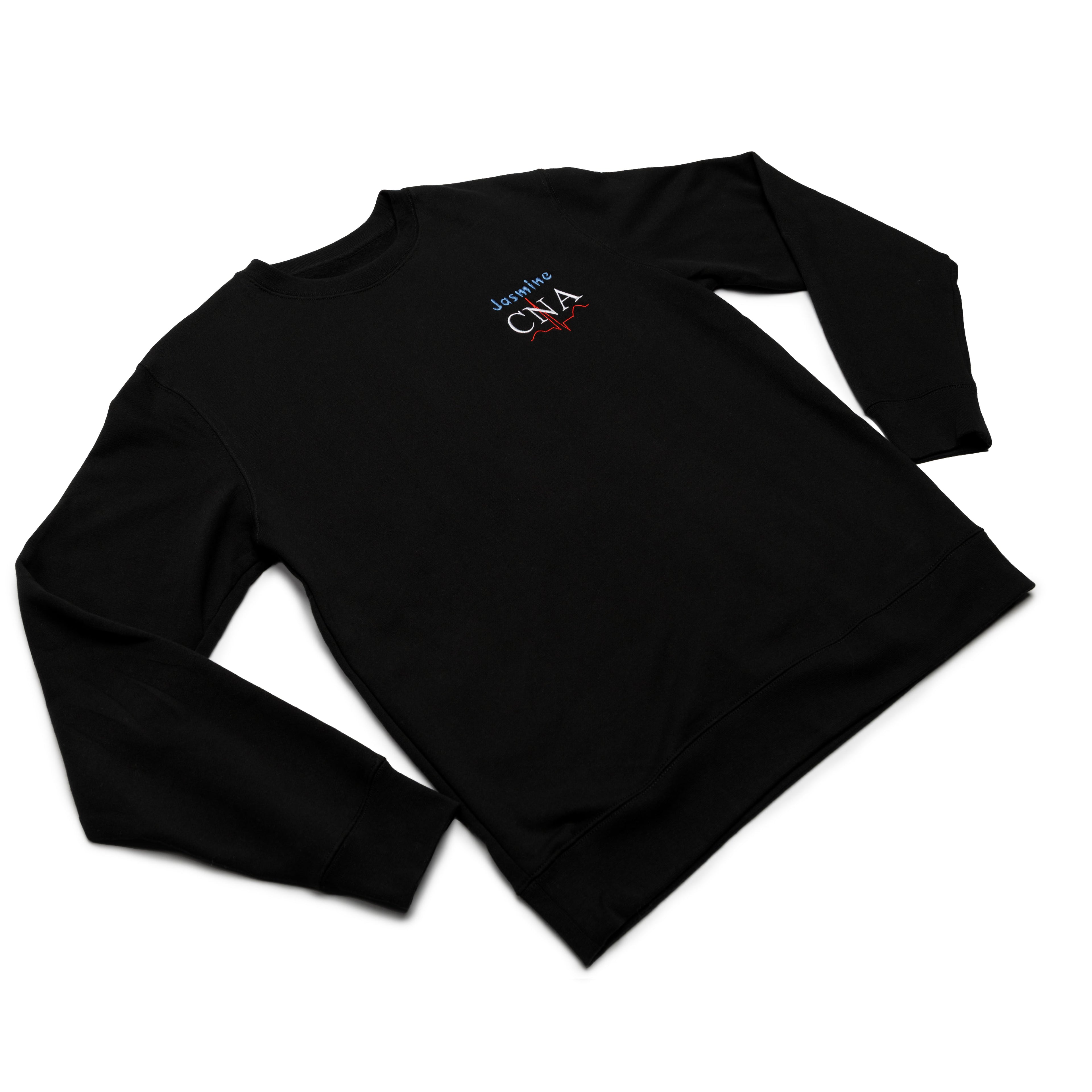 Black crewneck worn at an angle with a custom name and the CNA design embroidered on the chest