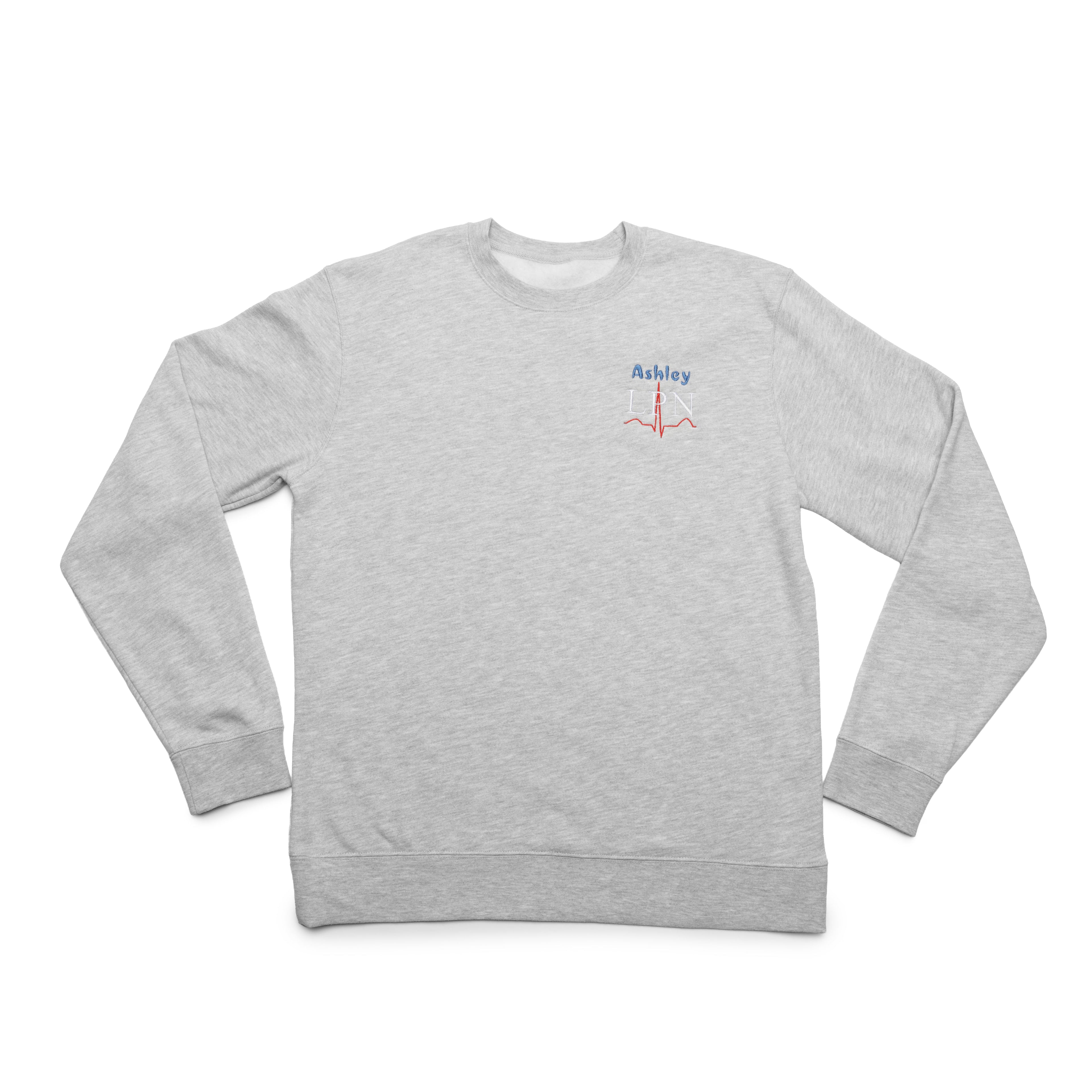 Grey Heather crewneck laid flat with a custom name and the LPN design embroidered on the chest