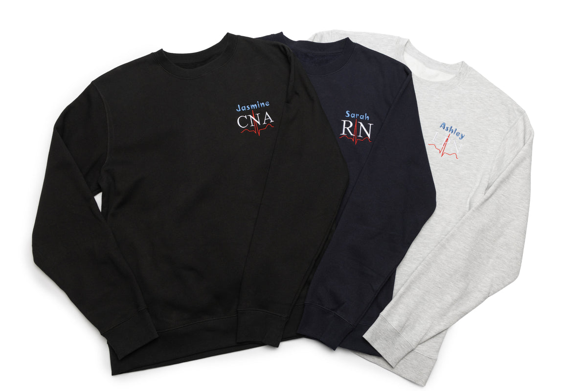 Three Lead II crewnecks stacked together, each personalized with a name and credential design