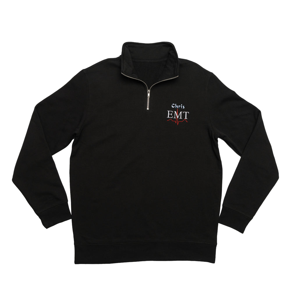 Black quarter-zip laid flat with a custom name and the EMT design embroidered on the chest