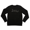 Black crewneck laid flat with the Powered by Caffeine and Trauma design embroidered on the chest