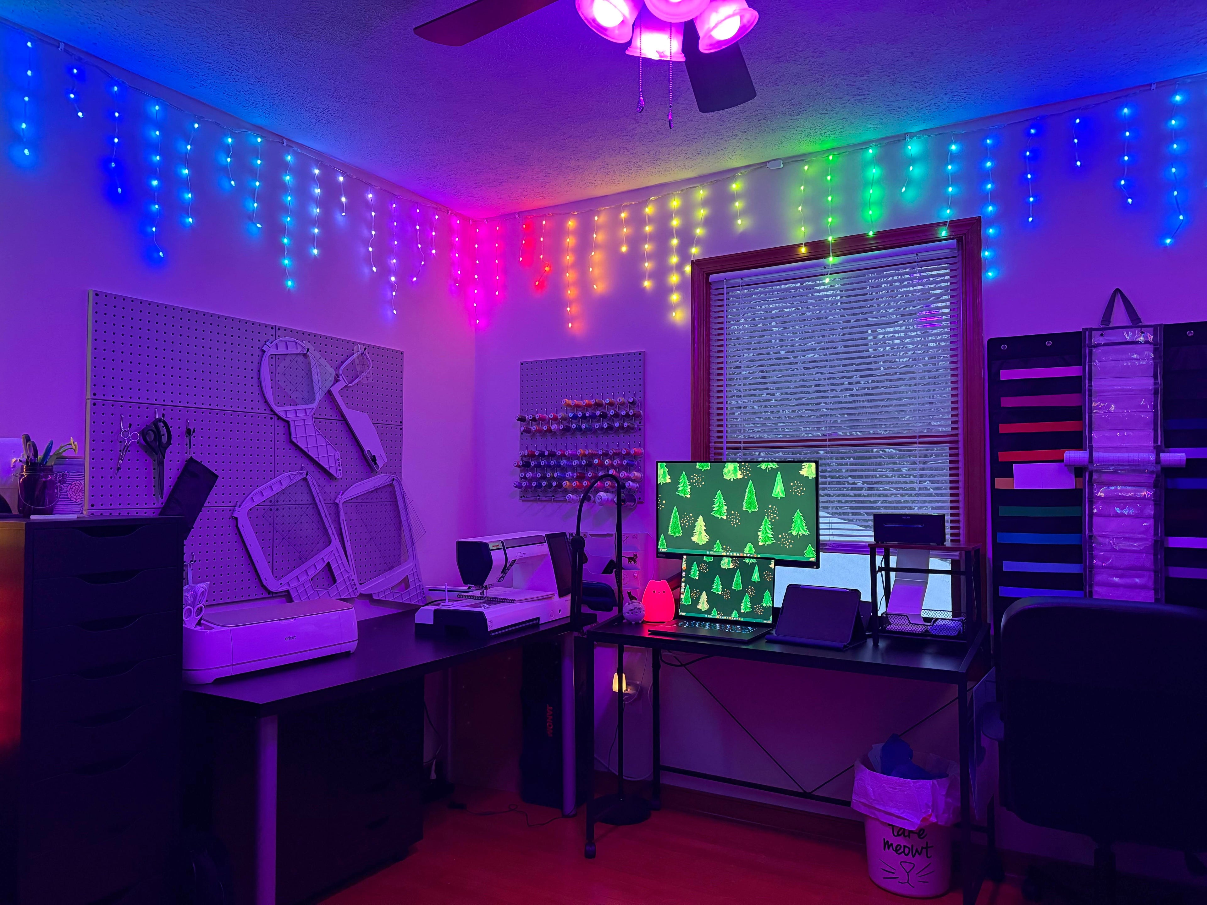 Room with colorful LED lights on the ceiling and walls, featuring a desk with computer equipment.